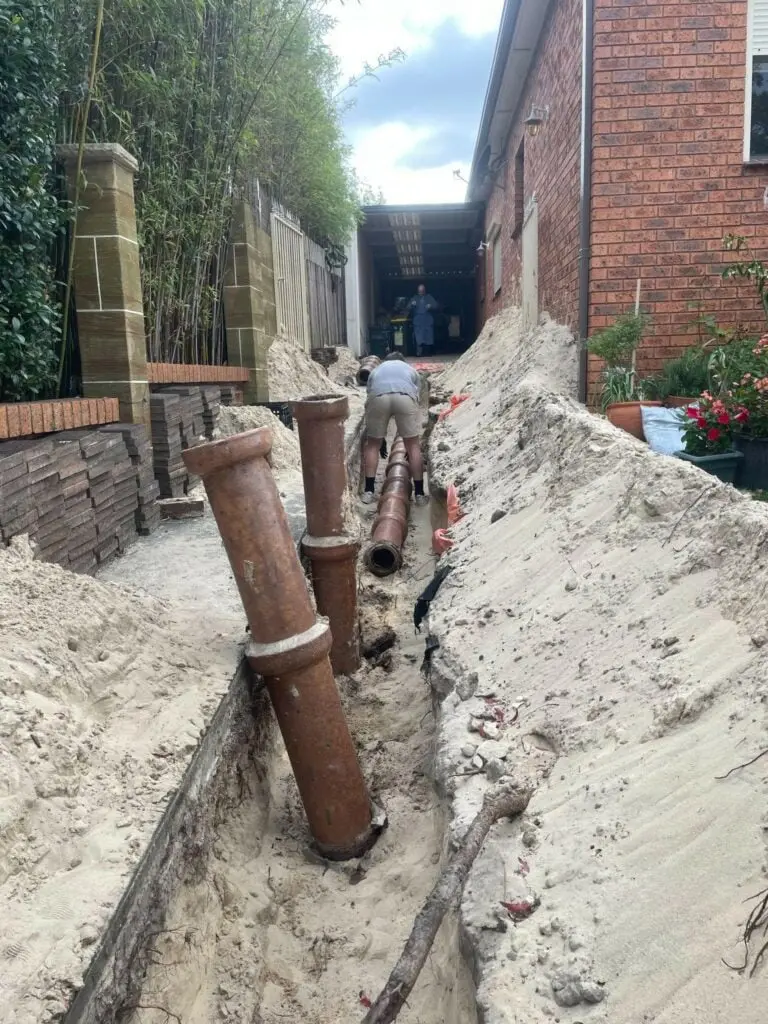 Old sewer pipes dug up in a trench along a side passage